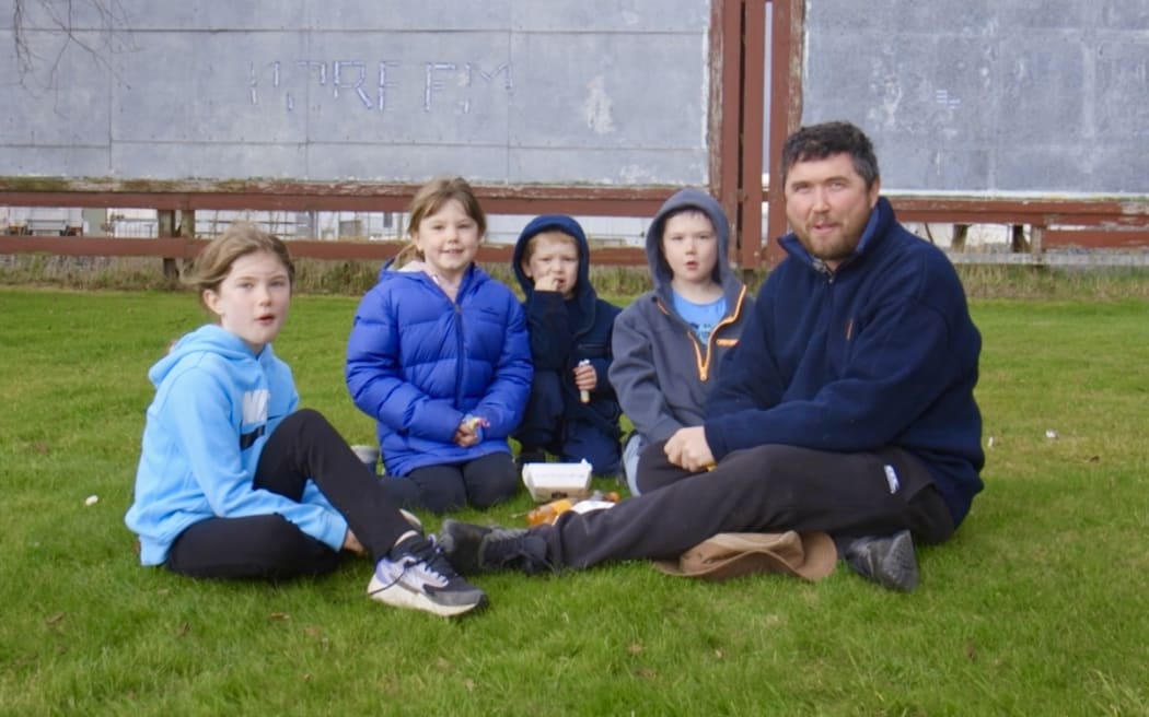 A dad and his children enjoy a picnic during the parade.