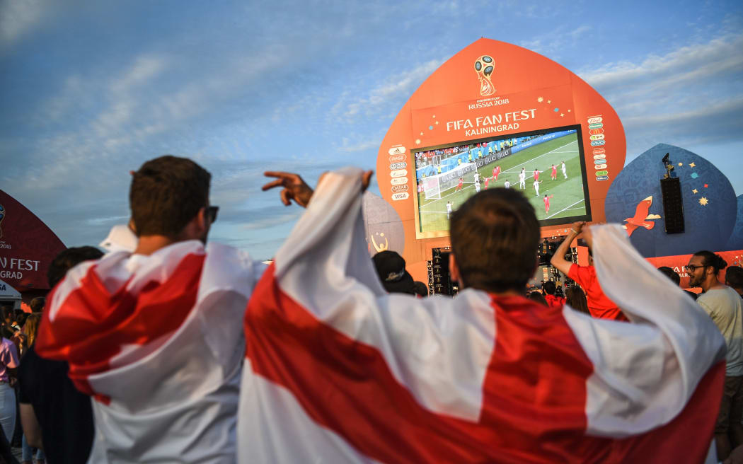 English fans celebrate their team's opener at the Fifa Fan Fest area in Kaliningrad as they watch the Russia 2018 World Cup Group G football match between Tunisia and England at the Volgograd Arena in Volgograd on June 18, 2018. / AFP PHOTO