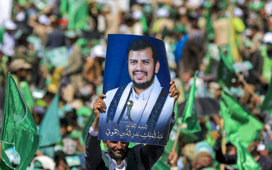 A Yemeni lifts a portrait of Huthi leader Abdul Malik al-Houthi during a ceremony marking the birth anniversary of Islam's Prophet Mohammad, in Sanaa on September 27, 2023. Known as "Al-Mawlid al-Nabawi", Muslims across the world will celebrate the prophet's birthday on the 12th day of the third month of the Islamic calendar. (Photo by MOHAMMED HUWAIS / AFP)