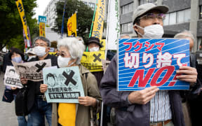 Demonstrators hold slogans during a protest outside the Japanese prime minister's office against the government's plan to release treated water from the Fukushima nuclear plant into the ocean, on April 13, 2021.