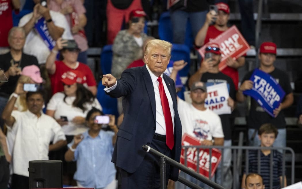 Former US President and 2024 Republican presidential candidate Donald Trump points to the crowd as he leaves after speaking during a campaign rally at the Georgia State University Convocation Center in Atlanta, Georgia, on August 3, 2024. (Photo by CHRISTIAN MONTERROSA / AFP)