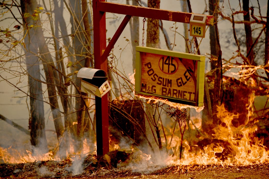A bushfire burns outside a property near Taree, 350km north of Sydney on November 12, 2019.