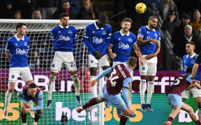 Everton's English defender #06 James Tarkowski (centre right) heads the ball away at a freekick taken by Burnley's Danish striker #34 Jacob Bruun Larsen (C) during the English Premier League football match between Burnley and Everton at Turf Moor in Burnley, north-west England on December 16, 2023. (Photo by Oli SCARFF / AFP) / RESTRICTED TO EDITORIAL USE. No use with unauthorized audio, video, data, fixture lists, club/league logos or 'live' services. Online in-match use limited to 120 images. An additional 40 images may be used in extra time. No video emulation. Social media in-match use limited to 120 images. An additional 40 images may be used in extra time. No use in betting publications, games or single club/league/player publications. /