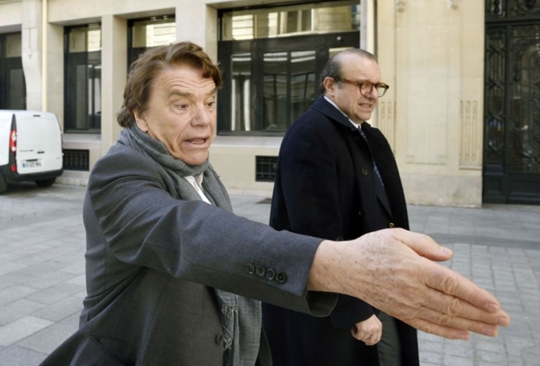 French businessman Bernard Tapie (L) flanked by his lawyer Herve Temime, arrives for a hearing at the financial pole on March 12, 2015.
