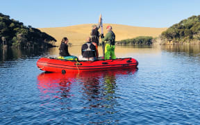 Collecting a sediment core from Lake Wai Raupo in Northland.