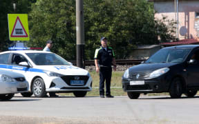 Traffic police officers block the road in the small town of Oktyabr'skoye near Simferopol, on July 22, 2023. A Ukrainian drone attack on Crimea on July 22 blew up an ammunition depot, sparking evacuations on the Moscow-annexed peninsula and halting rail traffic.