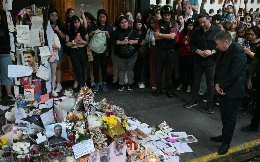 Geoff Payne (R), the father of One Direction pop singer Liam Payne, looks at the place where fans paid tribute to his late son outside the CasaSur Hotel in Buenos Aires on October 18, 2024.