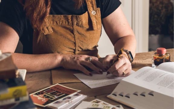Millie Blackwell, writing a letter.
