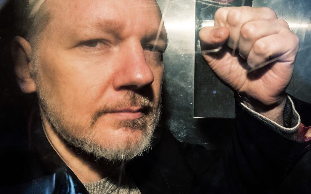 WikiLeaks founder Julian Assange gestures from the window of a prison van as he is driven into Southwark Crown Court in London on May 1, 2019, before being sentenced to 50 weeks in prison for breaching his bail conditions in 2012.