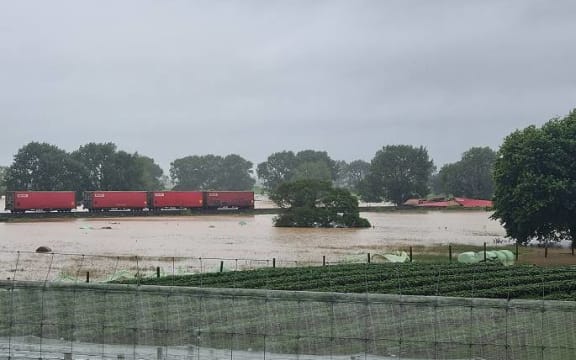 Flood waters surround the derailed train in Te Puke.