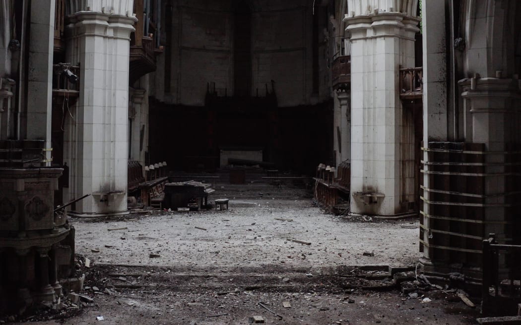 A photo taken inside the Christ Church Cathedral shows a piano covered in dust and debris, in Christchurch on 16 August 2022.