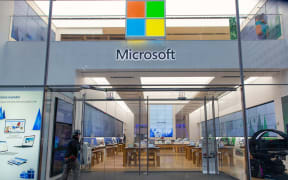 People walk past a Microsoft store entrance with the company's logo on top in midtown Manhattan at the 5th avenue in New York City, US.