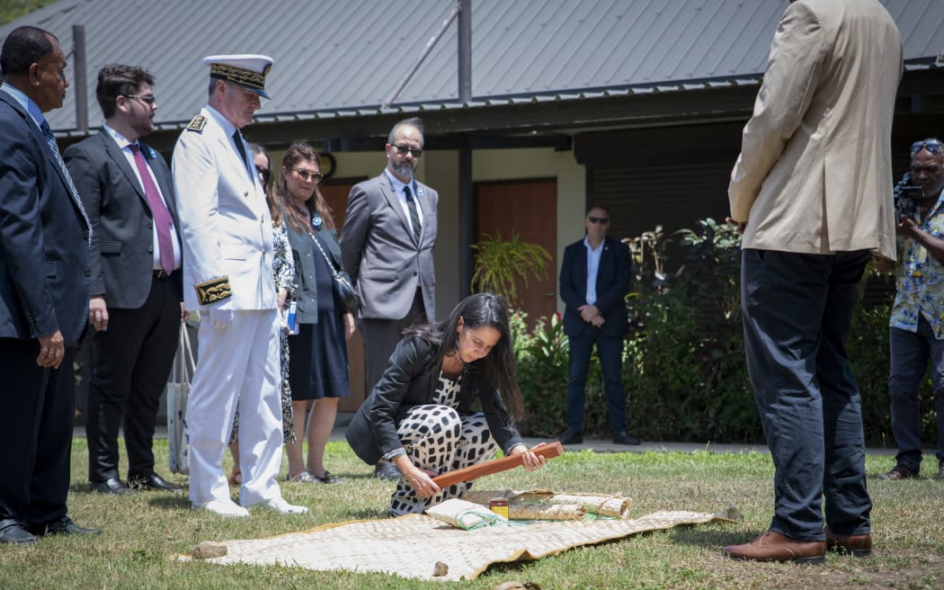 France's Minister for Overseas Naima Moutchou (C), accompanied by the High Commissioner of the Republic Jacques Billant, participates in her welcoming ceremony by the Customary Senate President Ludovic Boula (R) and other Caledonian officials in Noumea, in the French overseas collectivity of New Caledonia, on November 10, 2025. (Photo by Delphine MAYEUR / AFP)