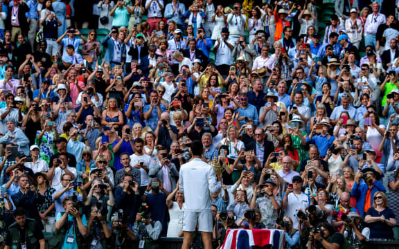 Novak Djokovic has his photograph taken by photographers and the crowd with the Wimbledon.