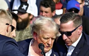 U. S. Republican presidential candidate former President Donald is surrounded by U.S. Secret Service agents in Butler, Pennsylvania on July 13, 2024. The former president suffered a gunshot wound to his ear after a suspect fired gunshots at his Pennsylvania rally and he survived the assassination attempt. According to the law official, the suspected shooter was killed by the Secret Service. ( The Yomiuri Shimbun ) (Photo by Takayuki Fuchigami / Yomiuri / The Yomiuri Shimbun via AFP)