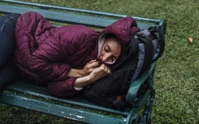 File image: A homeless woman sleeps on a bench