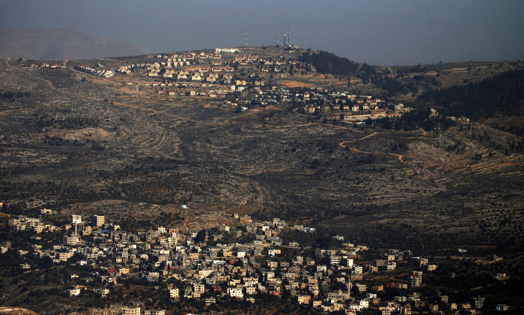 A picture, taken from Nablus, shows in the foreground the Palestinian West Bank village of Azmout and in the background the Jewish settlement of Elon Moreh