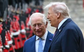 Britain's King Charles III (L) and US President Donald Trump (R) talk as they inspect a guard of honour during a ceremonial welcome in the Quadrangle at Windsor Castle, in Windsor, on 17 September, 2025, during the US president's second State Visit.