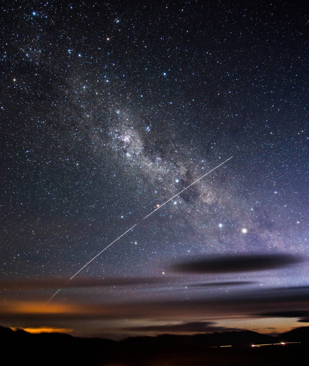 a photo of a night sky, with a streak of light across it