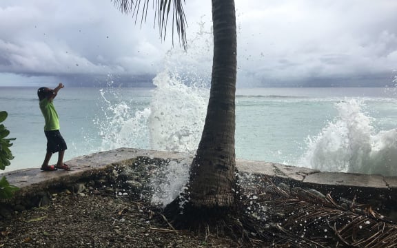 In this photo from last month's peak high tide in Majuro, a local youngster reacts as king tide-driven waves wash over a seawall on Majuro. Significantly higher tides are anticipated this week.