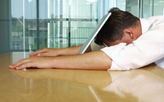 Businessman lying with face on laptop. (Photo by Téo Lannié / AltoPress / PhotoAlto via AFP)