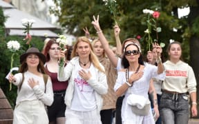 Women holding flowers protest against police violence during recent rallies of opposition supporters, who accuse strongman Alexander Lukashenko of falsifying the polls in the presidential election, in Minsk on August 13, 2020.