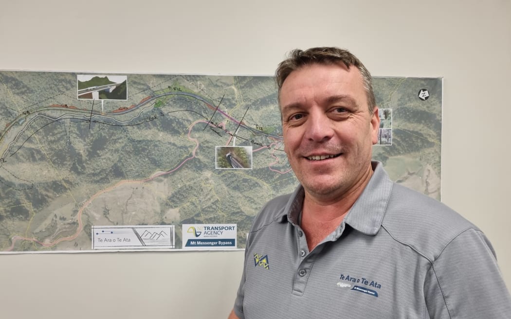 Waka Kotahi owner interface manager Chris Nally stands in front of a map of the Mt Messenger Bypass.