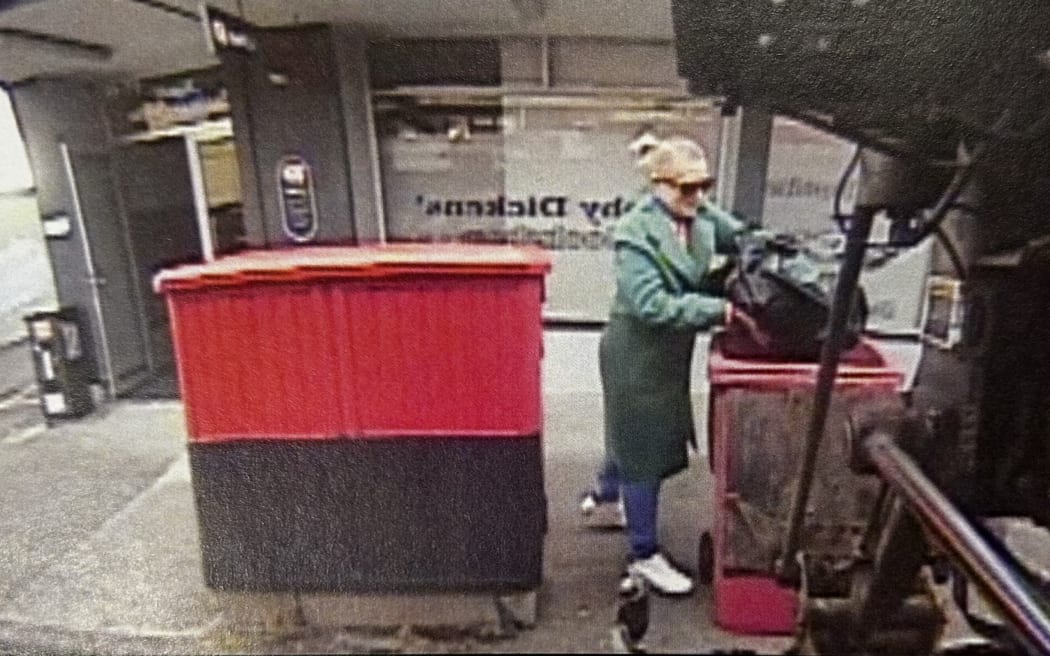 Julia DeLuney, pictured on CCTV from a camera on the side of a rubbish truck, placing a black bin bag in a rubbish bin at 6.58am on 25 January, 2024.