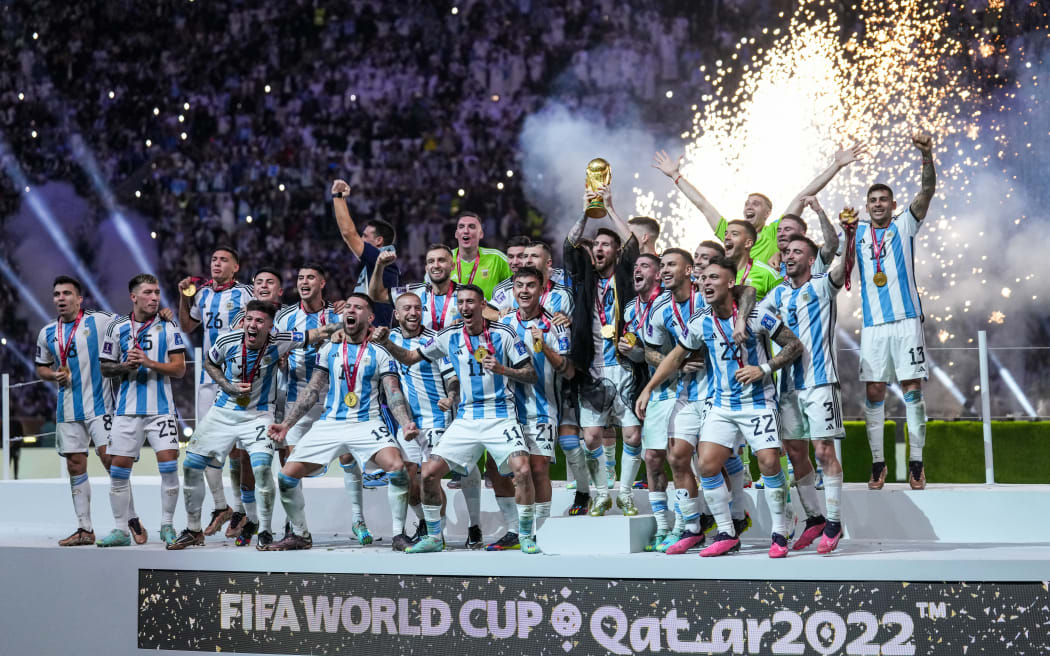 Lionel Messi of Argentina lifts trophy wearing a Bisht - traditional Arab robed as he lifts the world cup trophy surrounded by team mates uring after defeating France in a penalty shootout at the FIFA World Cup Qatar 2022 final.  (Photo by Ayman Aref/NurPhoto) (Photo by Ayman Aref / NurPhoto via AFP)