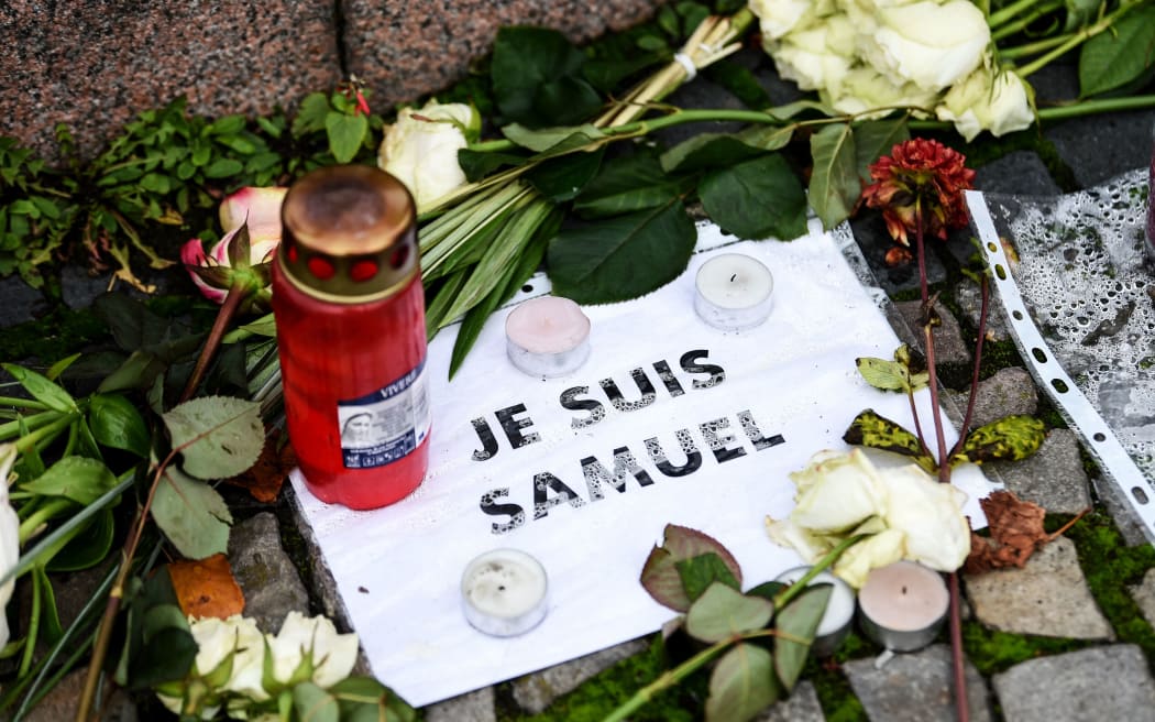 27 October 2020, Berlin: In front of the French embassy there are flowers, candles and a leaf with the inscription "Je suis Samuel". In a Paris suburb, the teacher Samuel Paty was murdered in the street by an alleged Islamist. Photo: Kira Hofmann/dpa-Zentralbild/dpa (Photo by Kira Hofmann / dpa-Zentralbild / dpa Picture-Alliance via AFP)