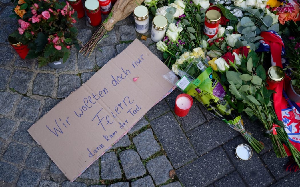 24 August 2024, North Rhine-Westphalia, Solingen: People lay flowers and light candles in Neumarkt in memory of the victims of the knife attack at the Solingen town festival. Several people were killed and injured in a knife attack on Friday evening at the city festival celebrating the 650th anniversary of the city of Solingen. Photo: Henning Kaiser/dpa (Photo by HENNING KAISER / DPA / dpa Picture-Alliance via AFP)
