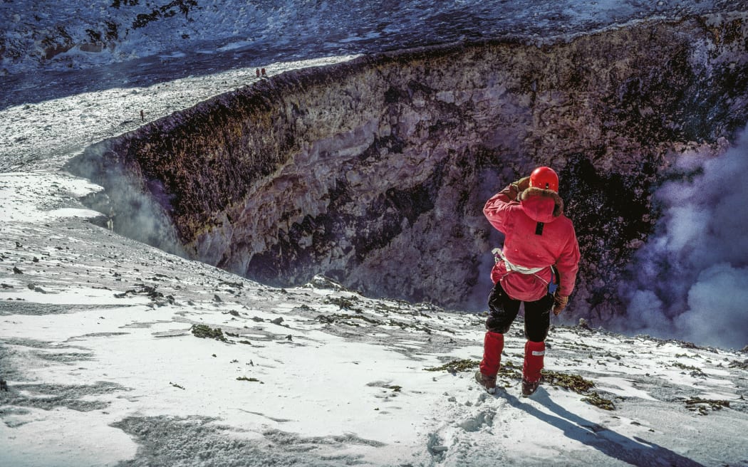 Harry Keys watches as team members on the lip of the Inner Crater throw ropes down the wall towards the lava lake. With swirling steam and gas filling the Inner Crater, it’s difficult to see if the ropes are long enough to reach the fumarole from which Werner Giggenbach can take his samples. COLIN MONTEATH