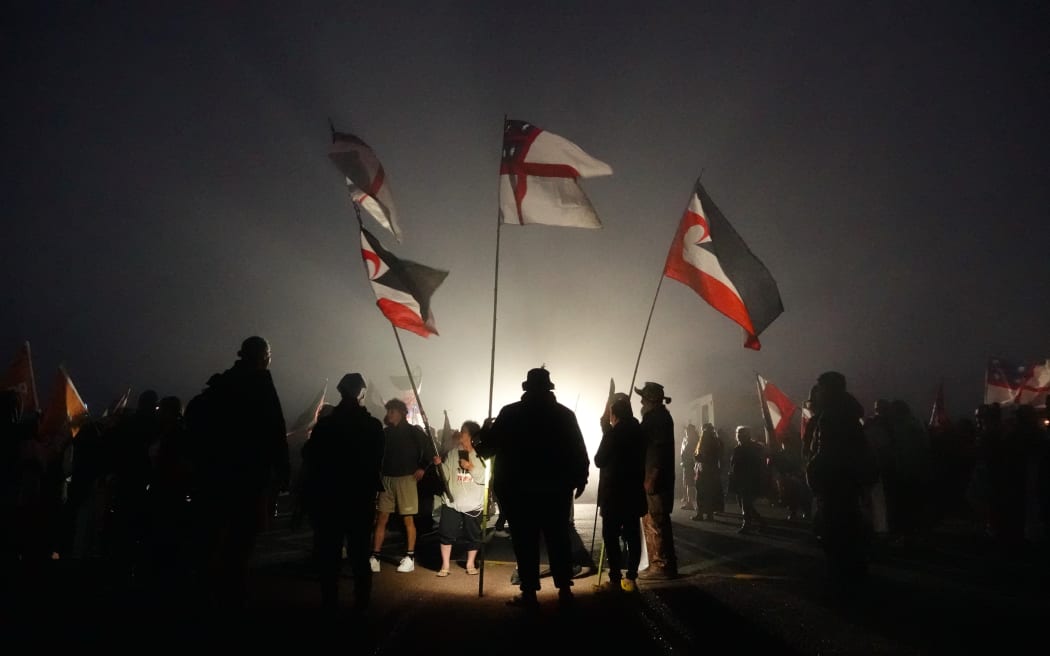 Marchers in the hīkoi gather before dawn at Cape Rēinga.