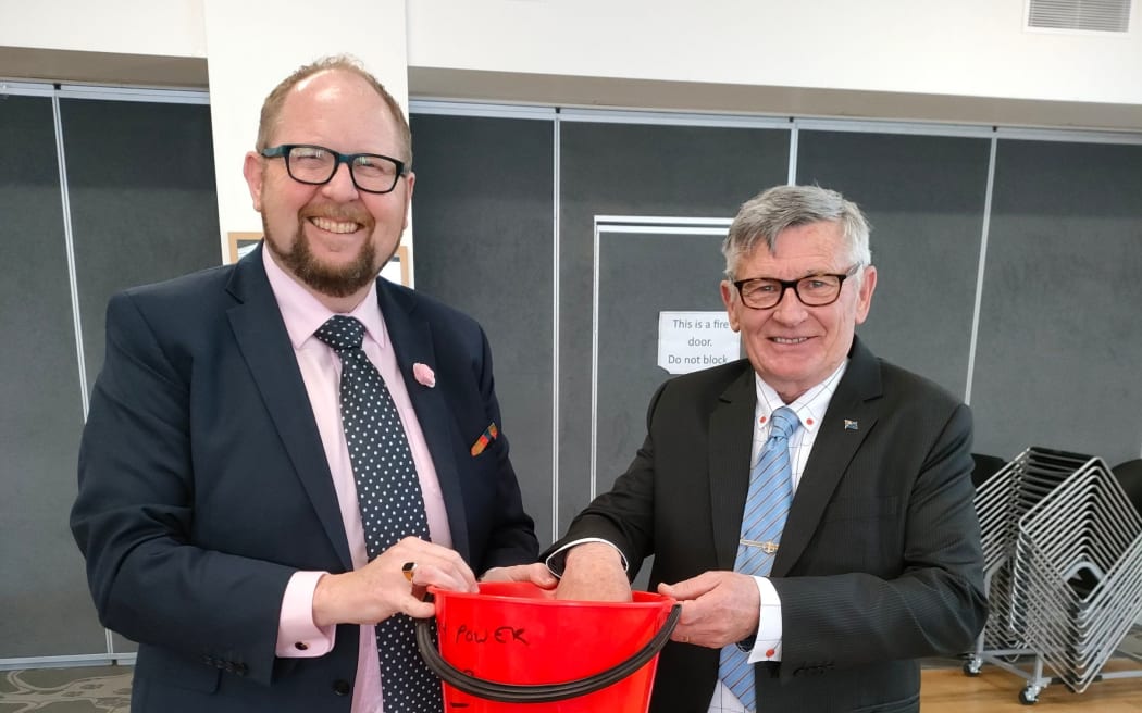 Waimakariri mayoral candidates Dan Gordon (left) and Paul Williams combine forces to draw the raffle at the end of a GreyPower meeting at the Rangiora RSA, where the pair squared off in a debate