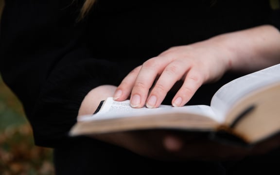 Cassie Dean leafs through the pages of her childihood bible, the New World Translation of the Holy Scriptures.