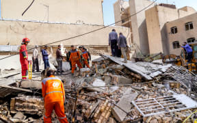 In this picture obtained from Iran's ISNA news agency, rescuers search through the rubble of a collapsed building at the site of a strike on a neighborhood, in Tehran on February 28, 2026. The United States and Israel launched strikes against Iran on February 28, with Israel's public broadcaster reporting that supreme leader Ayatollah Ali Khamenei had been targeted, as the Islamic republic retaliated with barrages of missiles at Gulf states and Israel. (Photo by AMIR KHOLOUSI / ISNA / AFP)