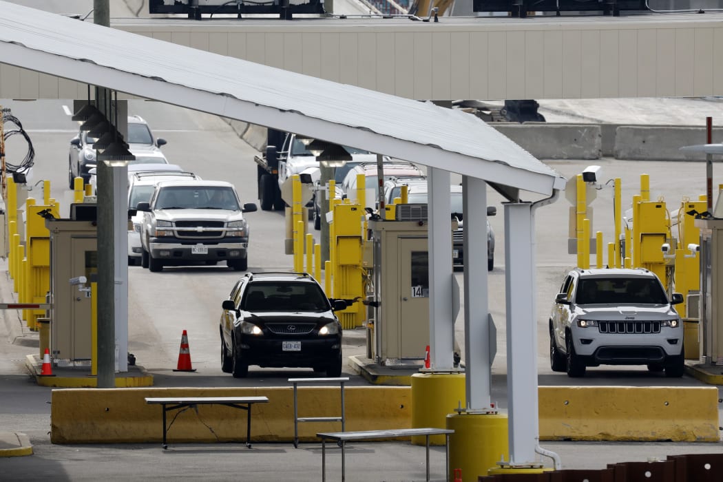 Vehicles cross at the US Customs between Windsor, Canada and Detroit, Michigan on 18 March.