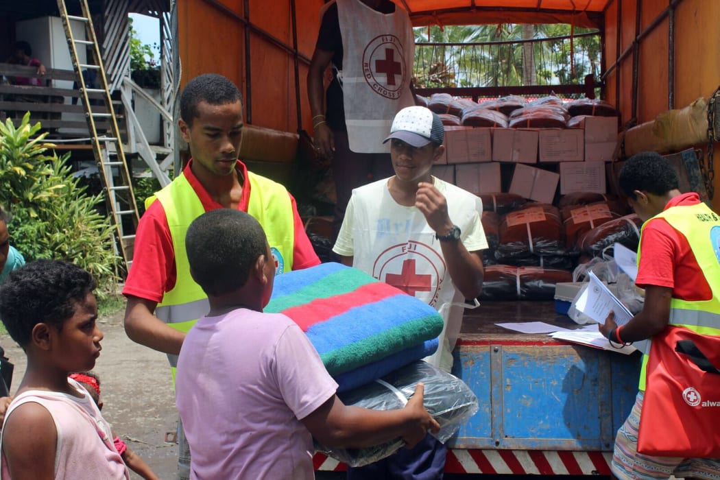 Members of the Red Cross hand out blankets.