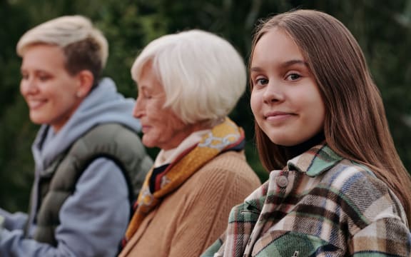 older woman in profile with two young people either side