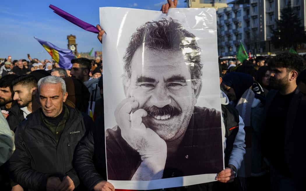 Supporters display a poster depicting the jailed leader of the Kurdistan Workers' Party (PKK) Abdullah Ocalan, 75, after he called on the Kurdistan Workers' Party (PKK) to disarm and dissolve itself in Diyarbakir, southeastern Turkey, on February 27, 2025. Abdullah Ocalan called on February 27, 2025 for his Kurdish militant group to lay down its weapons and dissolve itself in a landmark declaration read out in Istanbul. (Photo by Yasin AKGUL / AFP)