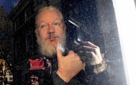 Julian Assange gestures as he arrives at Westminster Magistrates' Court in London, after the WikiLeaks founder was arrested by officers from the Metropolitan Police and taken into custody Thursday April 11, 2019.