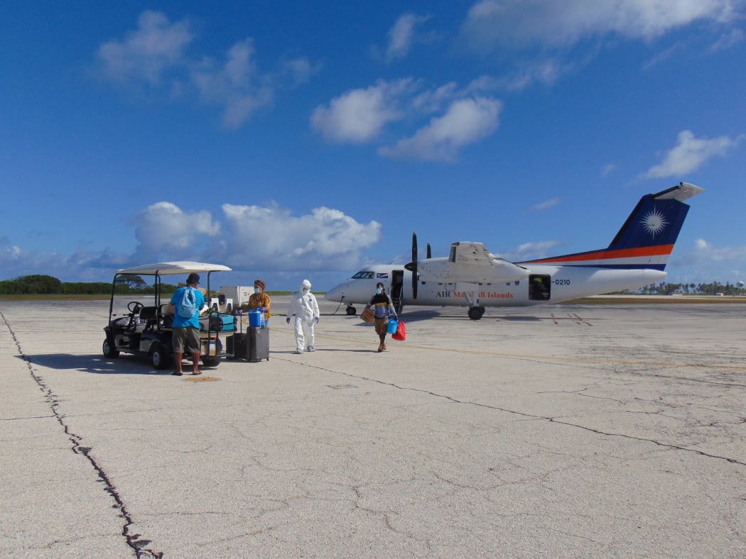 Godfrey Capelle, Connielynn Paul and Benjamin Thomas with a US Army official on arrival at the Kwajalein airport
