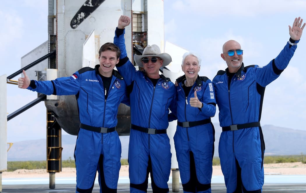 Blue Origins New Shepard crew (L-R) Oliver Daemen, Jeff Bezos, Wally Funk, and Mark Bezos pose for a picture near the booster after flying into space in the Blue Origin New Shepard rocket on July 20, 2021 in Van Horn, Texas.