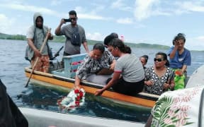 A family lays a wreath during the memorial service for the 14 people missing at sea.