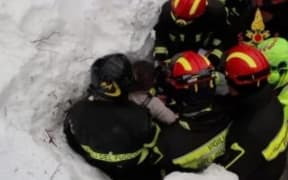Rescue workers pull a survivor from under the snow.