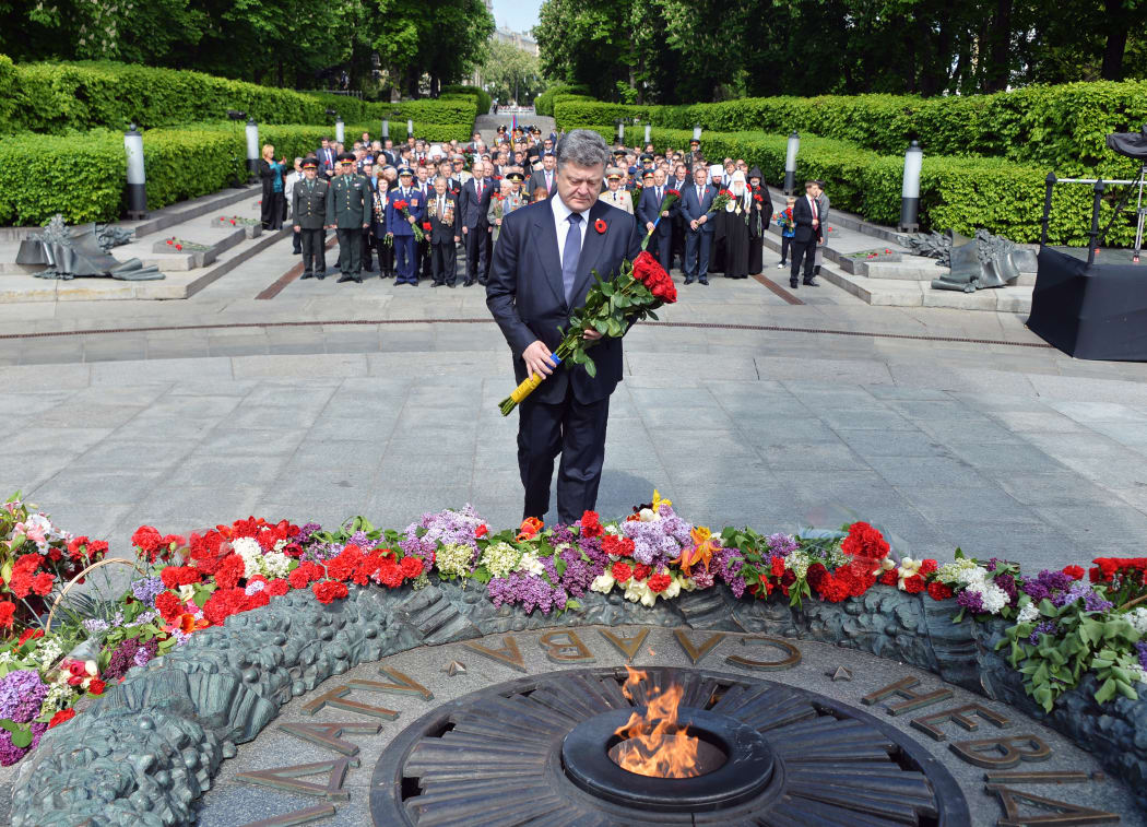 Ukrainian President Petro Poroshenko lays flowers at a memorial in Kiev on Saturday 9 May 2015.