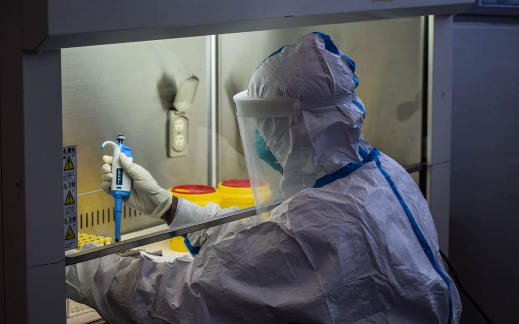 A technician handles samples from truck drivers testing for COVID-19 coronavirus at the laboratory of Kenya Medical Research Institute (KEMRI) in Busia, a town bordering with Uganda in western Kenya, on May 14, 2020. (Photo by Brian ONGORO / AFP)