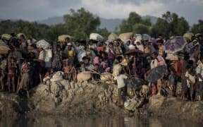 Rohingya refugees wait after crossing the Naf river from Myanmar into Bangladesh in Whaikhyang on October 9.
