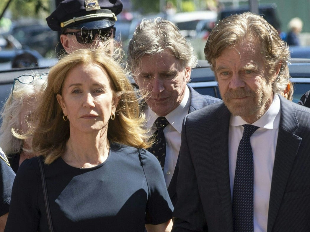Actress Felicity Huffman, escorted by her husband William H. Macy, makes her way to the entrance of the John Joseph Moakley United States Courthouse September 13, 2019 in Boston.