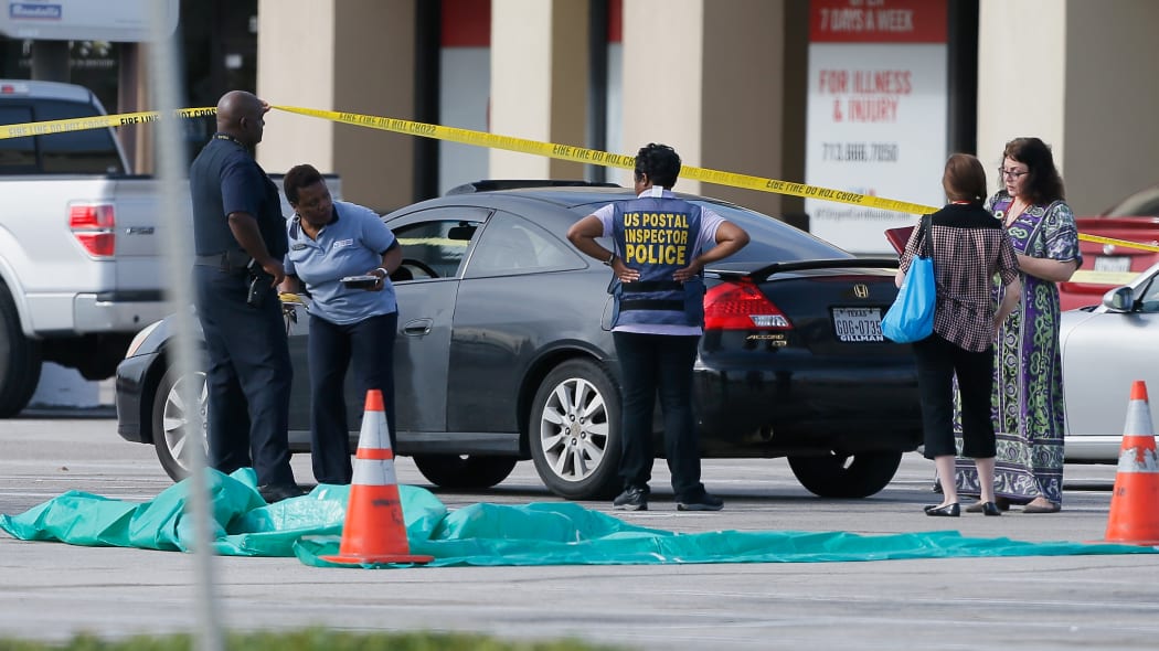 Investigators at a Houston mall where a guman wounded nine people before being fatally shot by police.